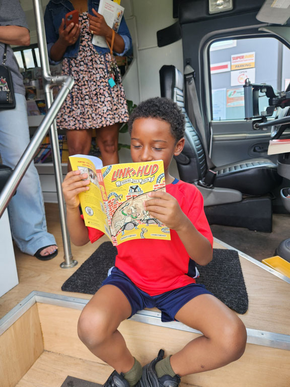 community member reading a book on the bus